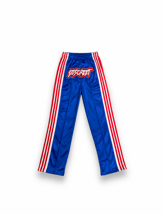 Royal blue Discreet track pants with red-and-white side stripes and a contrasting logo graphic
